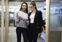 Business woman standing with her staff.